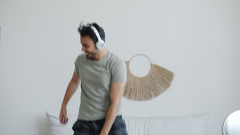 man dancing in bedroom with headphones