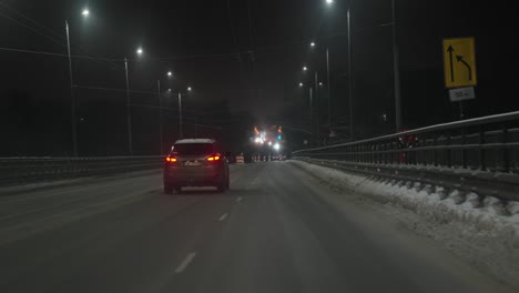 escena nevada de la calle principal en la noche de invierno, linternas en ambos lados, riga, letonia