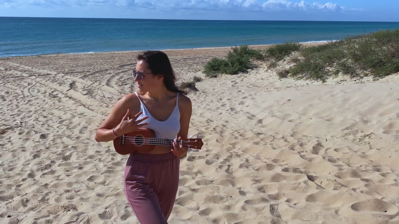 mujer tocando el ukulele en la playa