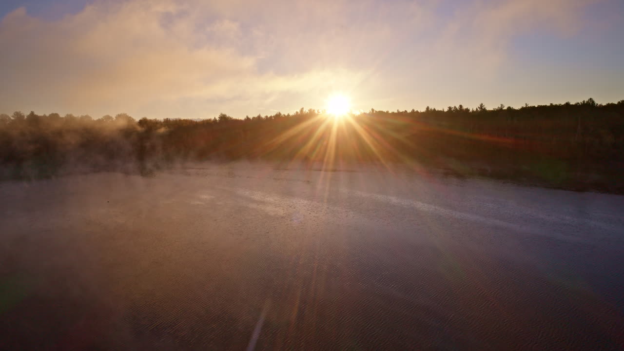 Aerial drone look at a river coursing through an autumn woodland