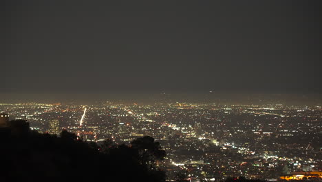 evening timelapse of the los angeles city lights with airliners landing in the distance