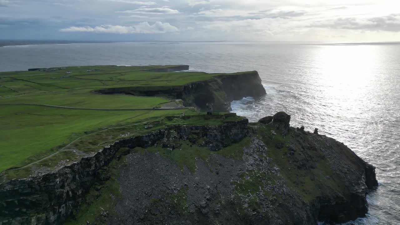 una toma aérea de una torre de vigilancia en ruinas en los acantilados de moher