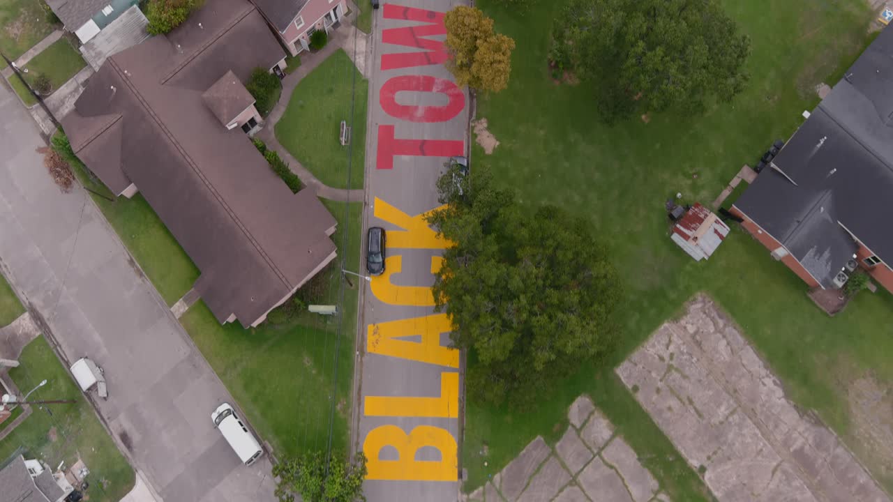 vista de pájaro de un gran cartel de "las ciudades negras importan" pintado en la calle en el histórico distrito de alturas de la independencia de houston