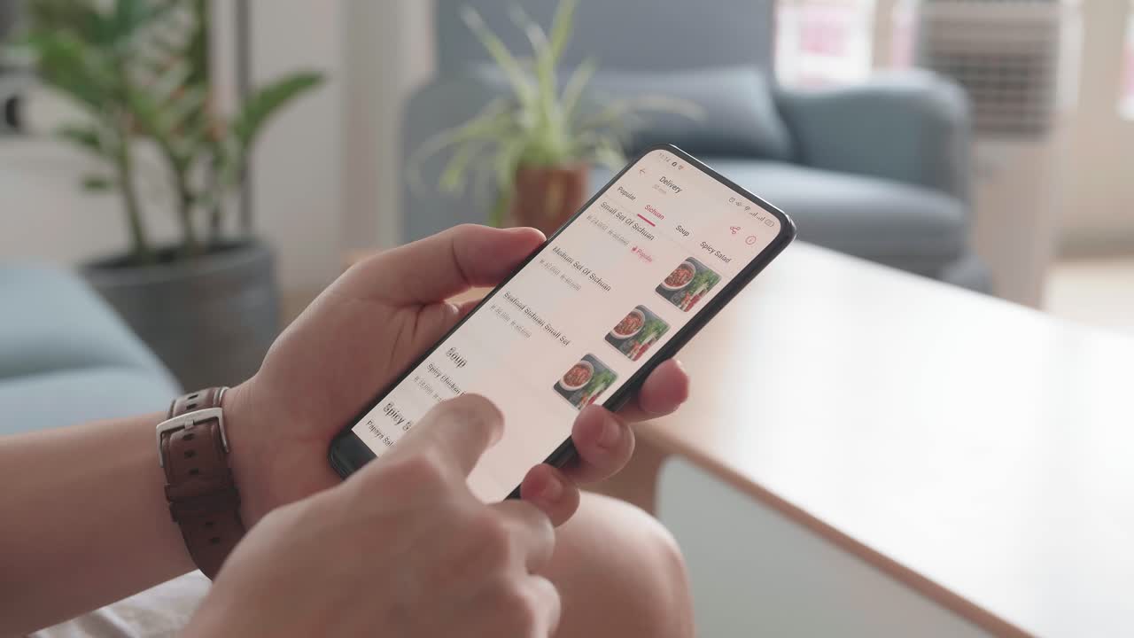 Close Up Of Man Hand Holding Smartphone And Orders Food In Online Store