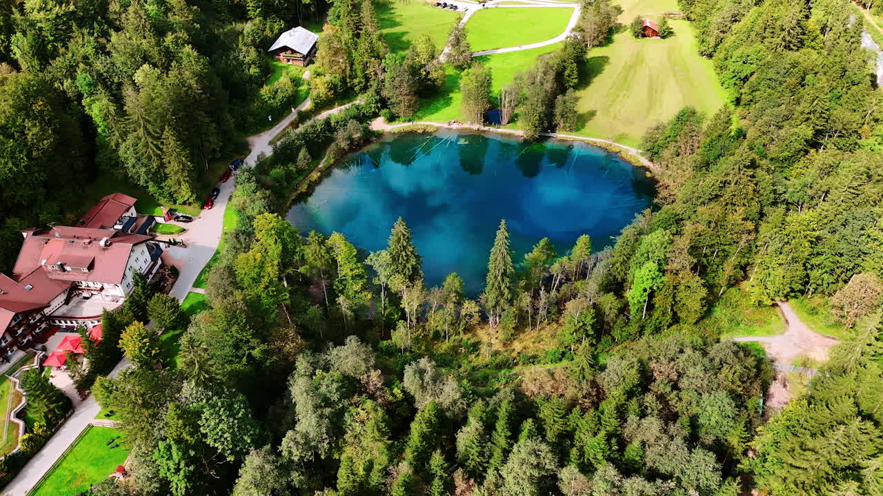 Small deep blue lake near a cozy hotel cottage. Spectacular top view on Christlessee lake, Oberstdorf, Bavarian Alps, Europe.