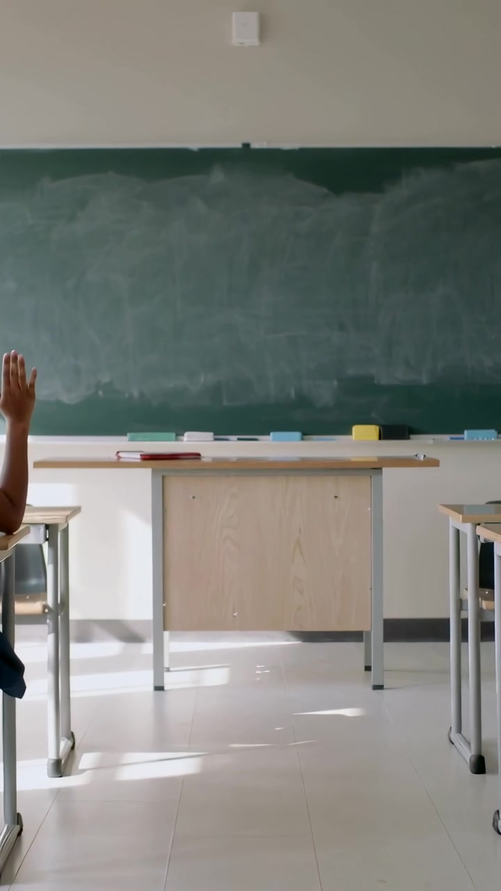 Video verticale: Mostra lavagna e banco dell'aula su frame4, studente in uniforme che alza la mano a sinistra