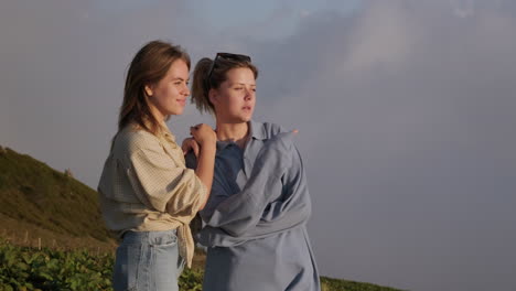 two friends enjoying the sunset view from the mountains