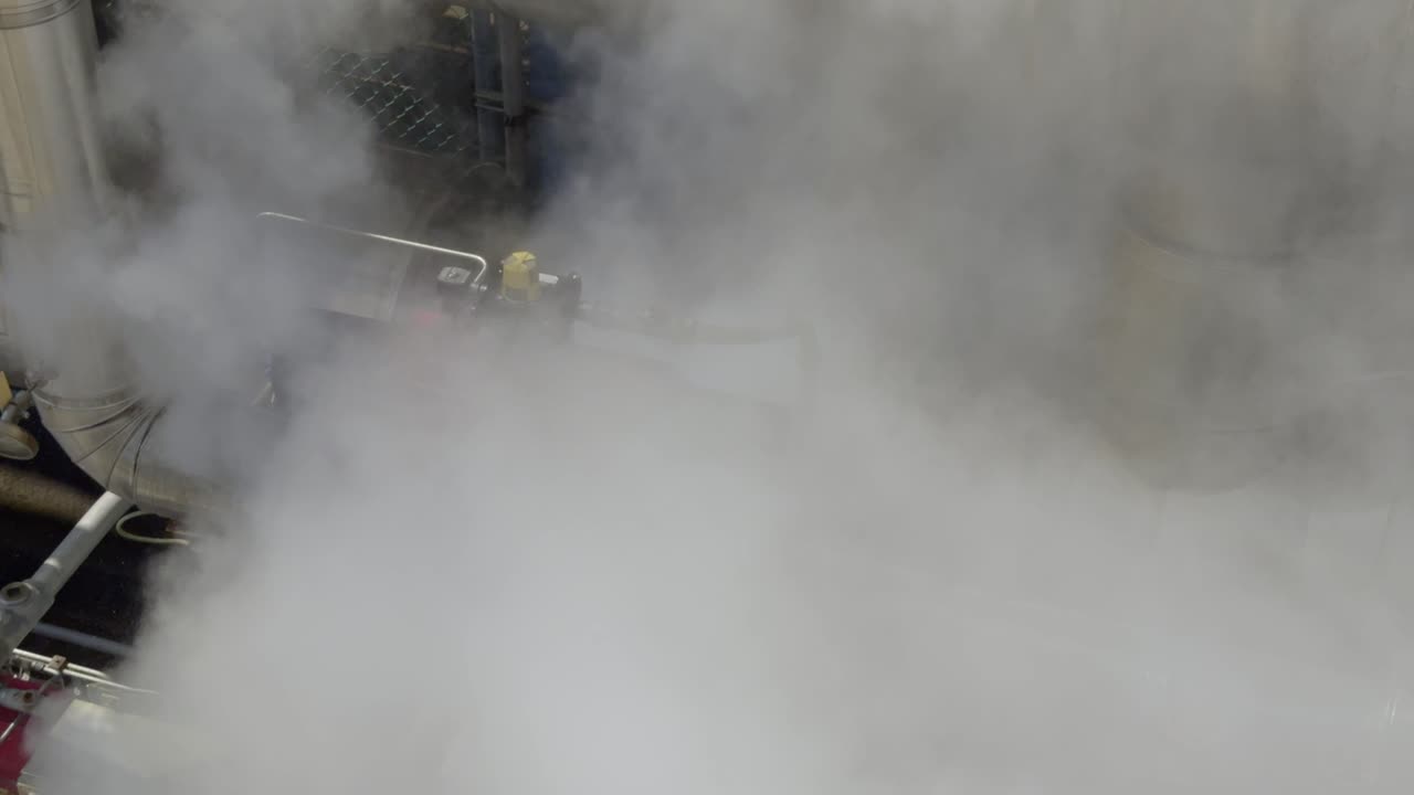 una válvula neumática industrial en una fábrica con una fuga de vapor