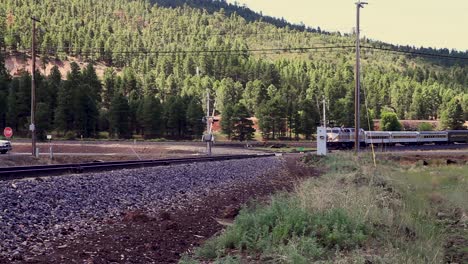 a passenger train approaches a railway crossing triggering the guard gates to drop