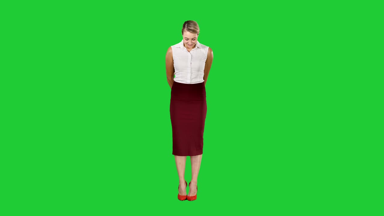 Attractive shy businesswoman standing and looking to the camera on a Green Screen, Chroma Key