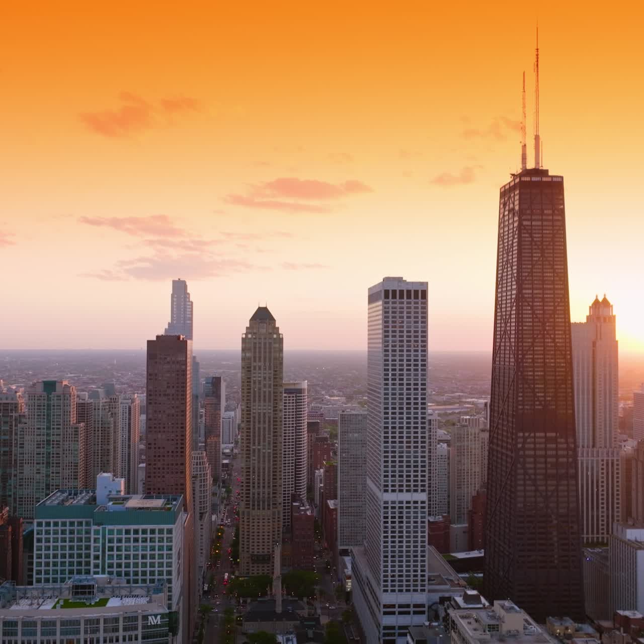 Paisagem fascinante da enorme cidade ao pôr do sol. Edifícios e ruas incríveis de Chicago, Illinois, com um plano de fundo de céu laranja