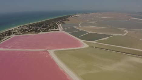 Vista-Aérea-De-Hermosos-Estanques-De-Sal-En-La-Costa-Durante-El-Mediodía