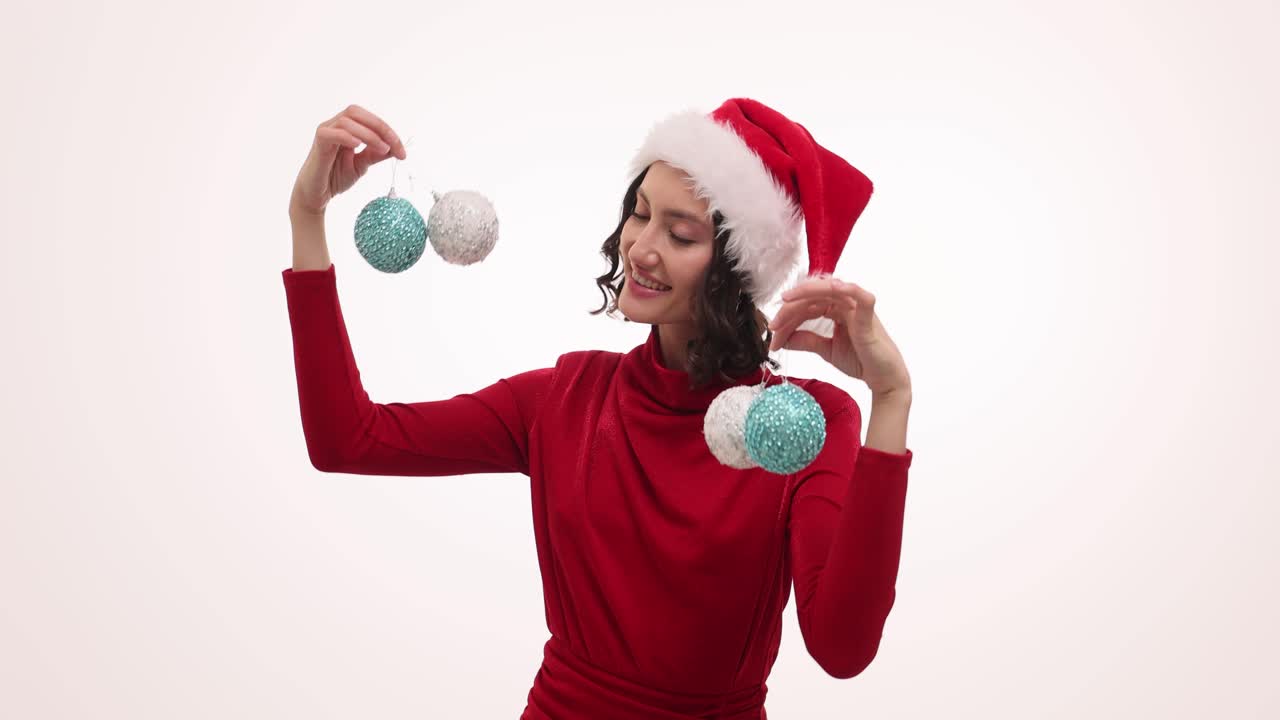 Happy Woman in Santa Hat and Red Dress with Christmas Ornaments