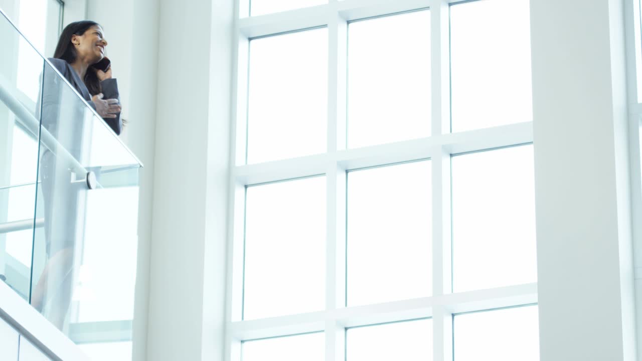 여성 매니저가 스마트폰에서 성공 소식을 듣고 있습니다.