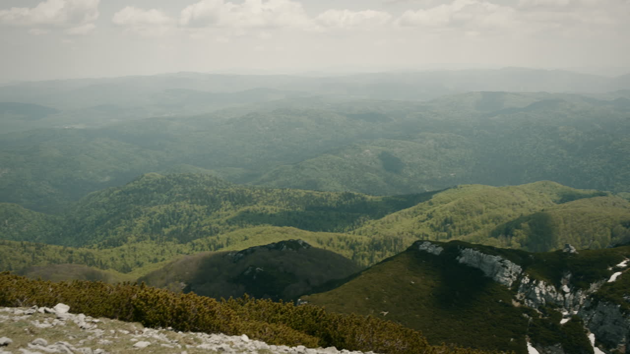 Una vista dalla cima del monte Snežnik, terreno carsico con paesaggio verde e rocce bianche.