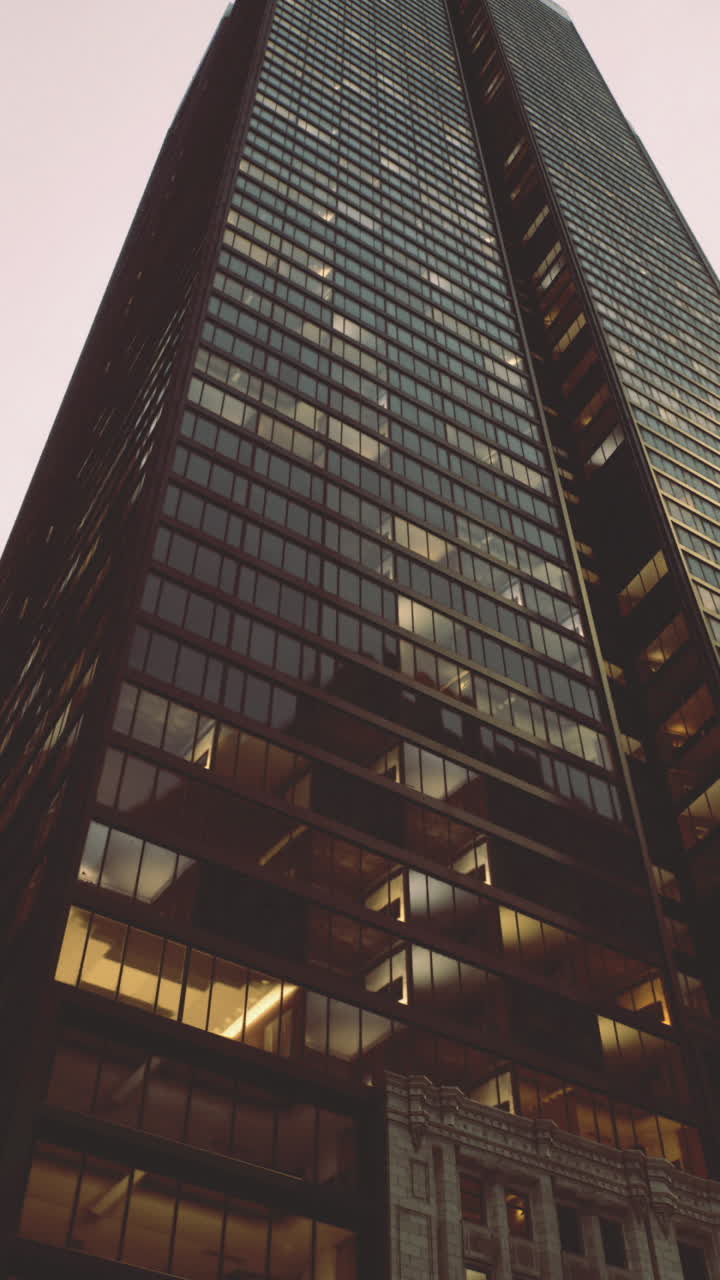 Tall skyscrapers in a bustling urban setting at twilight with glowing windows
