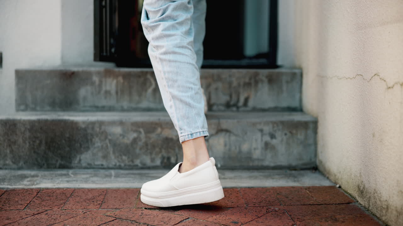 한 여자가 패키지를 들고 문으로 걸어가고 있다.