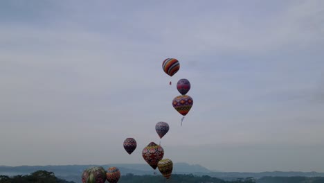 colorful hot air balloon epic flying on the sky - 4k orbit drone shot