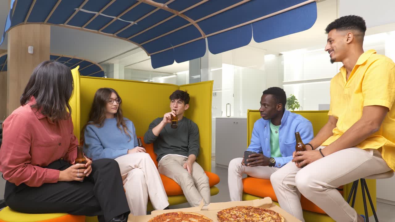Coworkers enjoying pizza and drinks during office break