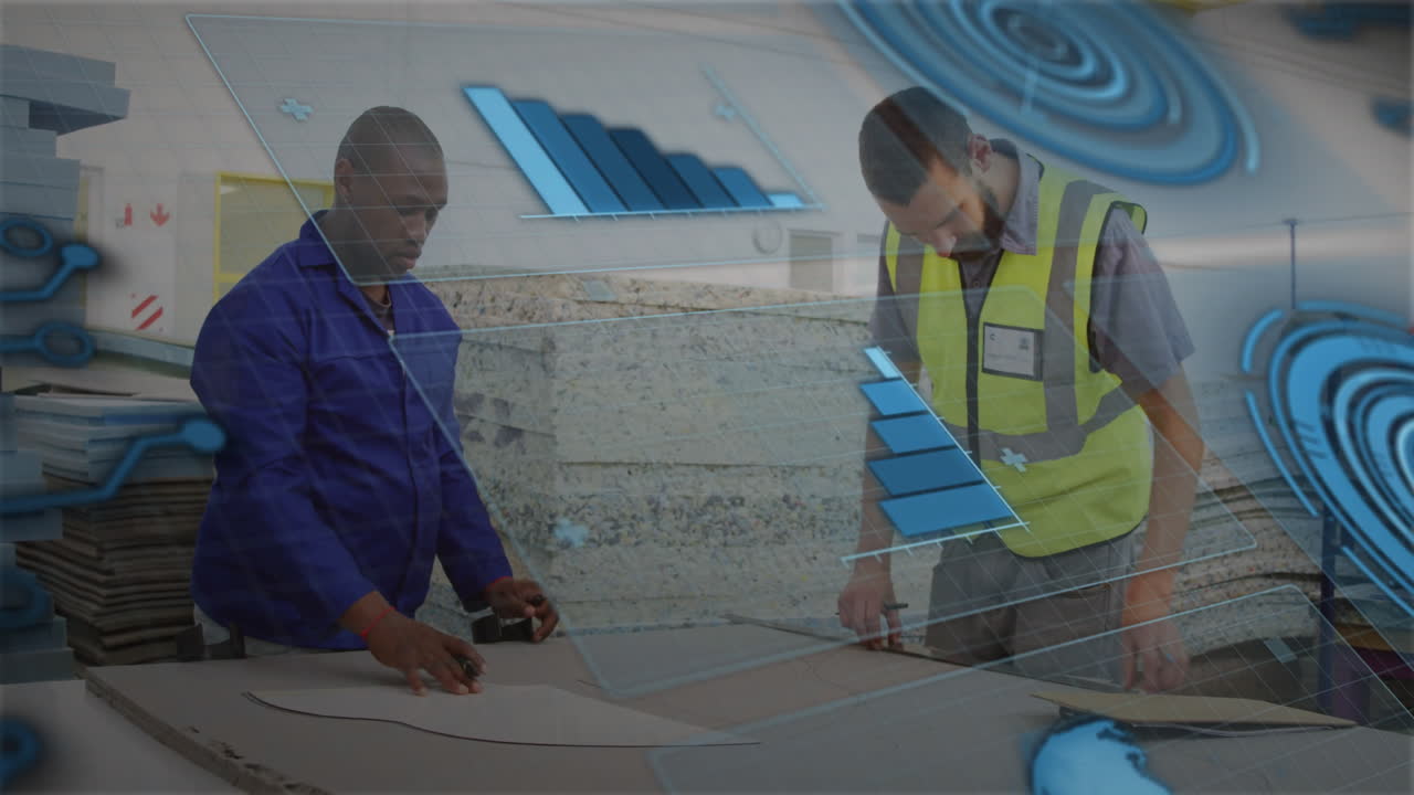 two workshop workers leaning over sheets marking cut lines in factory, showing animated bar charts