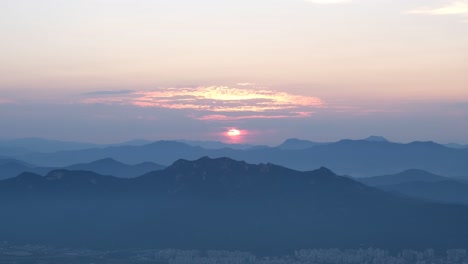 아시아 의 한국 에 있는 오렌지색 산맥 과 계곡 의 실루 을 보이는 해가 지는 것