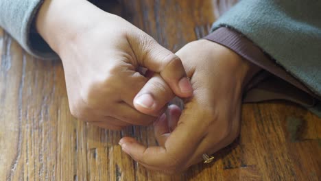 woman's hands on a wooden table