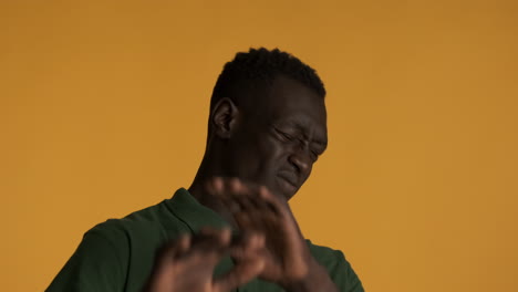 surprised and scared african american man on yellow background.