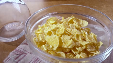 Crispy-yellow-corn-flakes-into-the-bowl-for-the-morning-a-delicious-Breakfast-with-milk.-Slow-motion-with-rotation-tracking-shot.