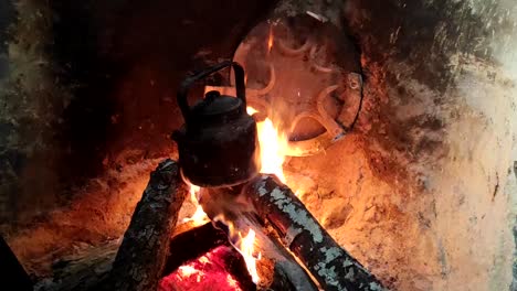 Close-up-of-cooking-dinner-in-a-pot-on-a-wooden-fire-in-a-brick-fireplace-in-a-traditional-kitchen-1