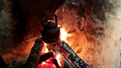 전통적인 부엌-1의 벽돌 벽난로에 있는 나무 불에 있는 냄비에 요리 저녁 식사 클로즈업