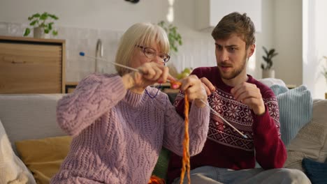 grandmother and grandson learning to knit together