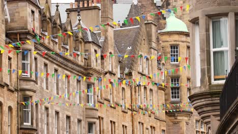 colorful flags adorn historic edinburgh buildings