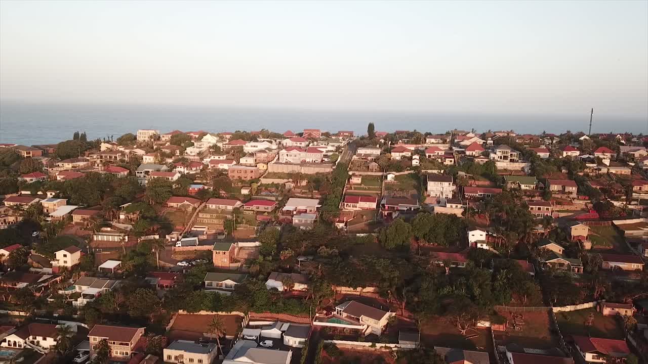 Drone che sorvola case residenziali colorate con una leggera vista mare in lontananza sul Bluff a Durban, Sudafrica