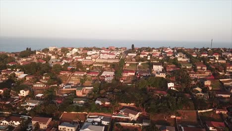 Drohne-Fliegt-über-Einige-Farbenfrohe-Wohnhäuser-Mit-Leichtem-Meerblick-In-Der-Ferne-Auf-Der-Klippe-In-Durban,-Südafrika