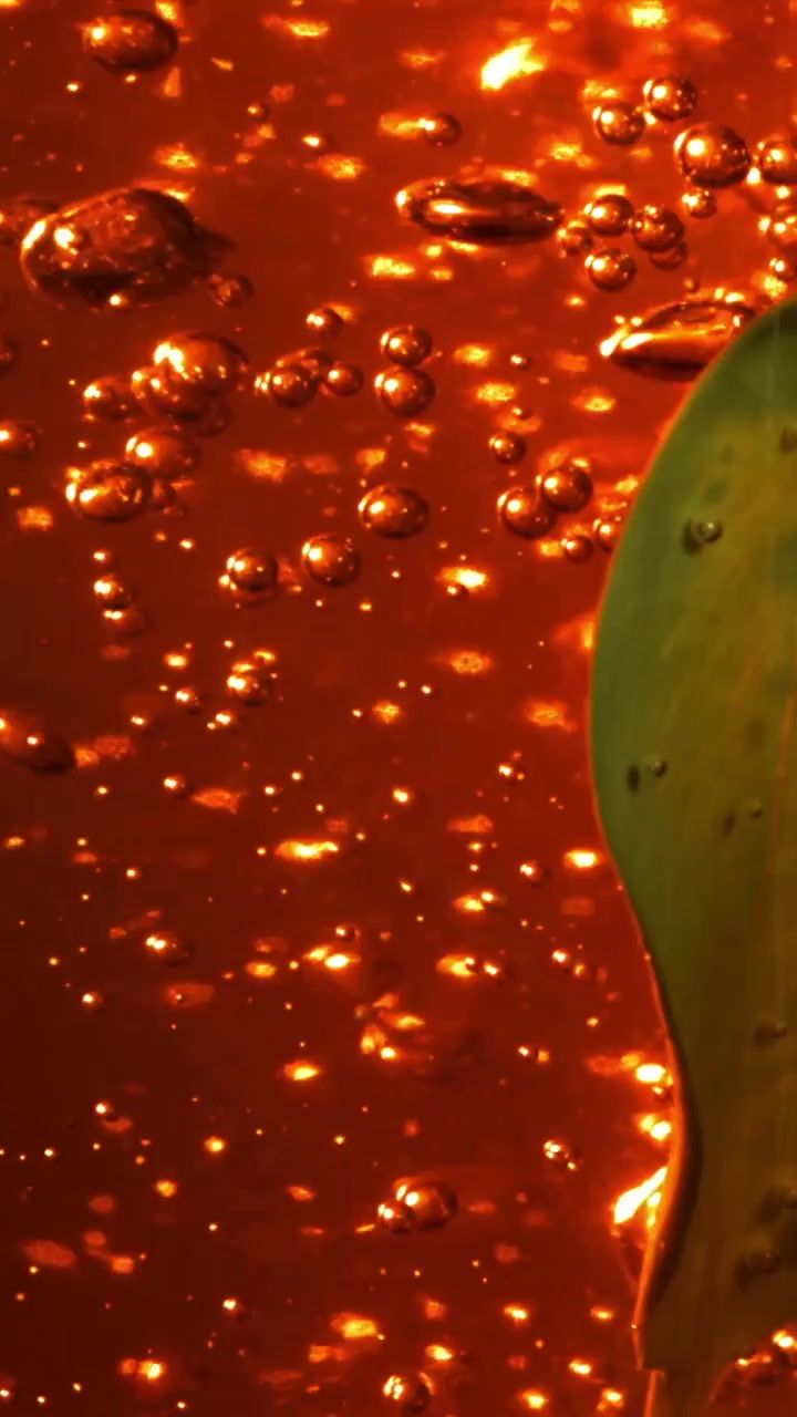 Ipnotizzanti bolle dorate arancioni scintillanti in un liquido viscoso