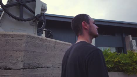 A-Young-Bearded-Man-With-His-Black-Shirt-Looking-Around-In-The-Street---close-up