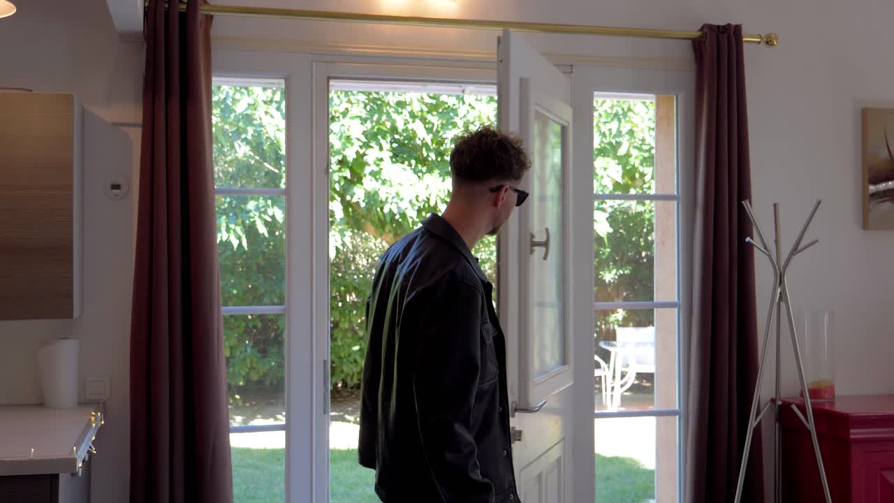 Two young men opening front door and walking inside the house.