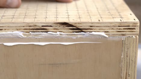 sealing a hand made wood box and wiping off the excess glue by hand