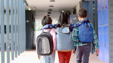 in school, three young biracial students are walking together