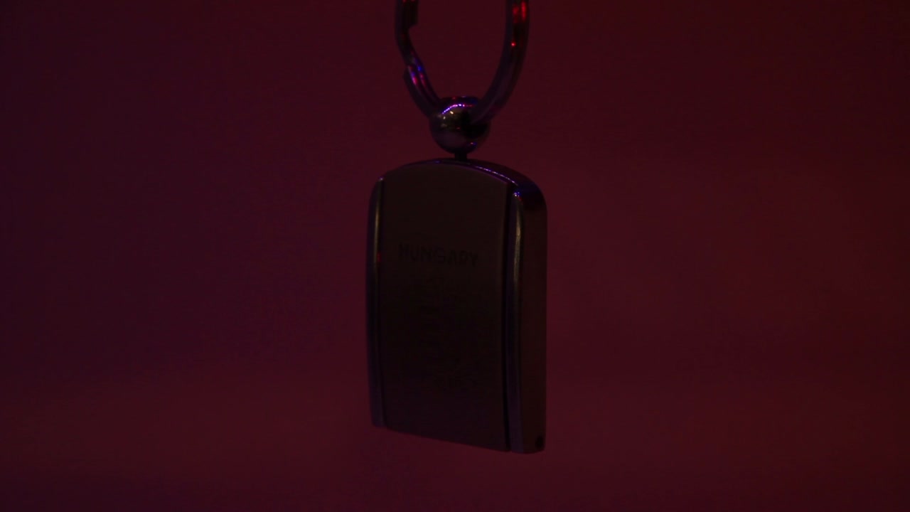 primer plano del llavero de recuerdo de metal de hungría y la luz láser en movimiento