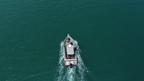 Un-Barco-Que-Conduce-A-Través-De-Aguas-Azules,-Una-Pequeña-Carta-De-Pesca-O-Un-Barco-De-Recreo-En-El-Agua-Del-Océano