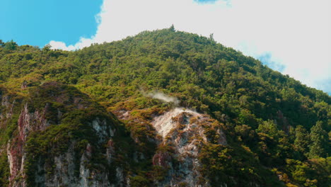 Steam-coming-off-Rainbow-Mountain,-Rotorua,-New-Zealand