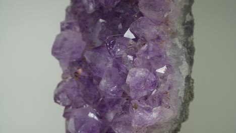 Ein-Felsen-Voller-Leuchtender-Amethyste,-Die-Sich-Im-Uhrzeigersinn-Drehen---Nahaufnahme