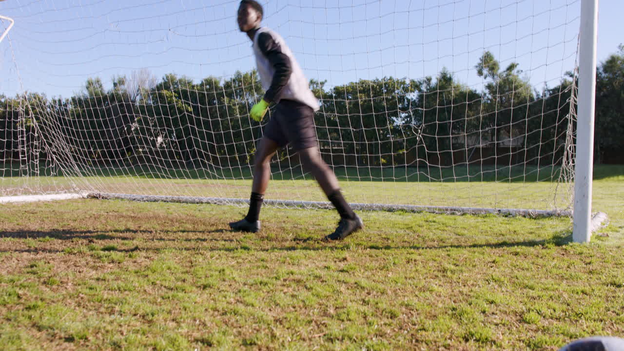 Goalkeeper in soccer uniform standing in goal, ready to defend shot