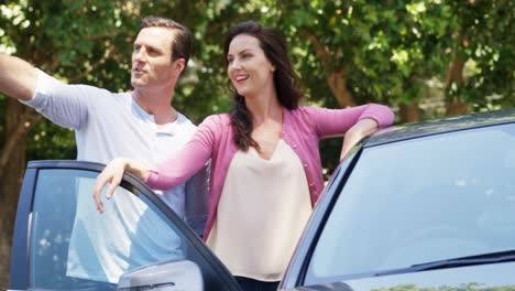 Couple-taking-a-selfie-on-mobile-phone-near-car