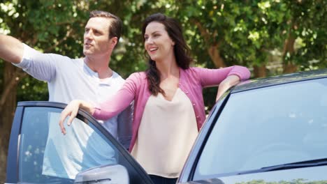 pareja tomando un selfie en el teléfono móvil cerca del coche