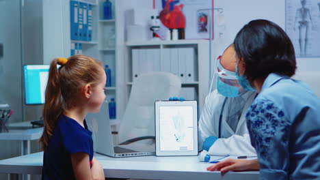 especialista médico que presenta el esqueleto utilizando la tableta