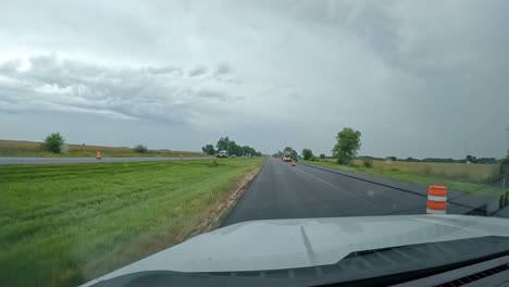 pov- driving thru a construction zone on the interstate in the midwest on a cloudy, rainy summer day