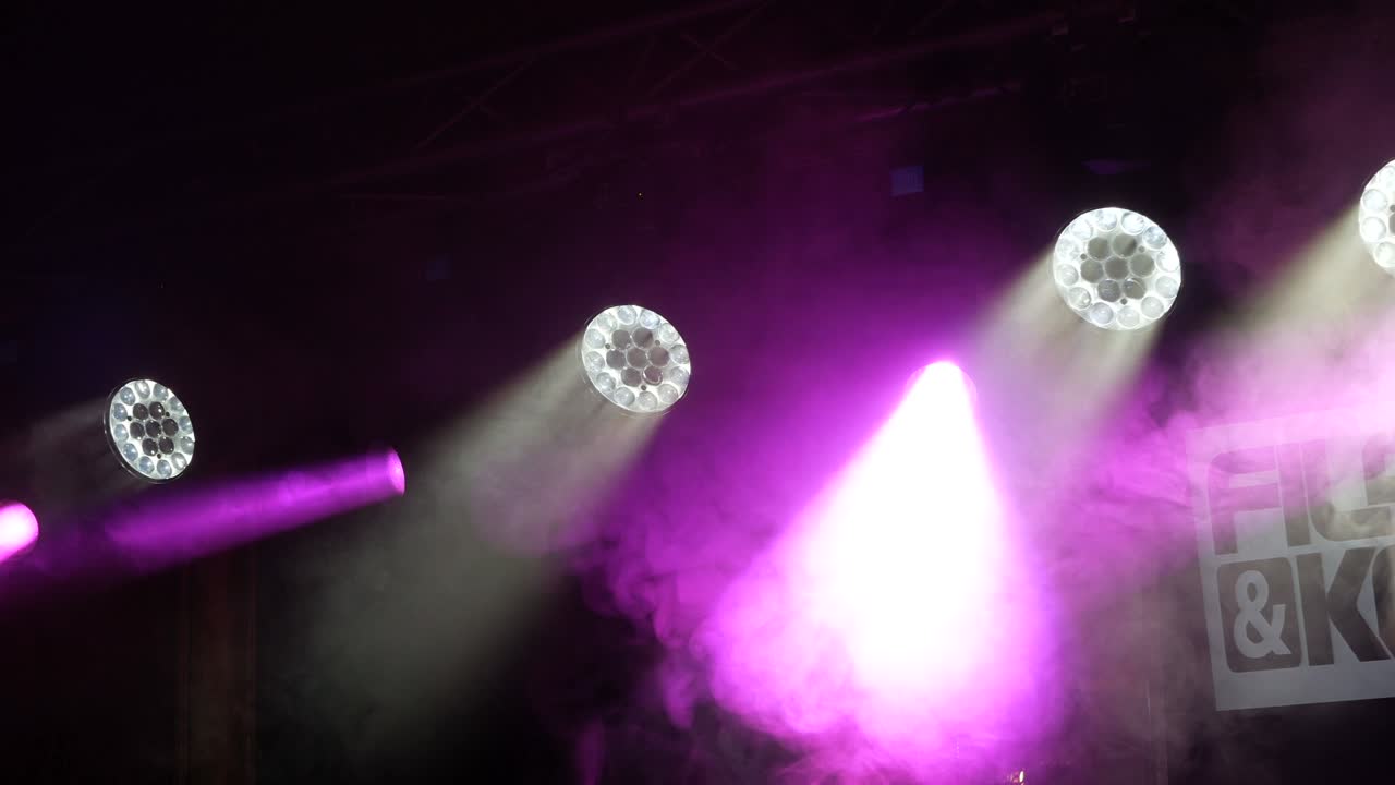 Lighting devices on a stage in action. Lilac and white.