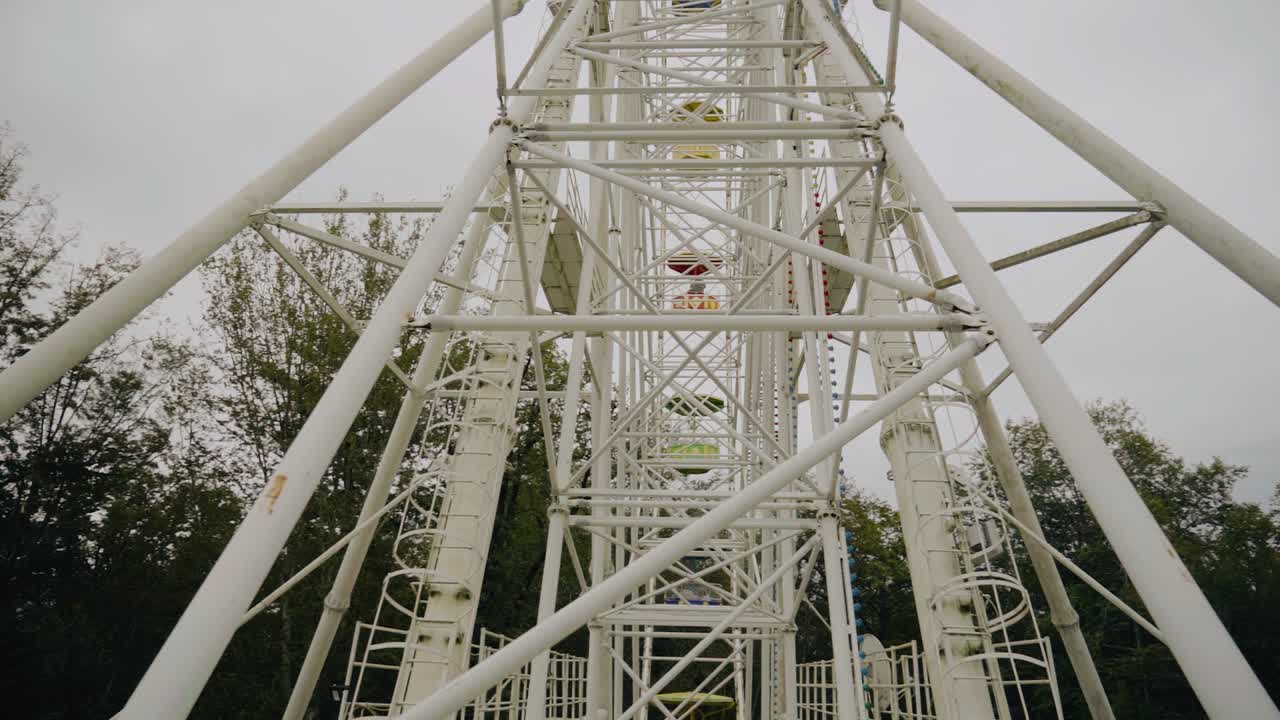 Panorama of a rotating ferris wheel in the mountains among nature. Shooting with a wide-angle lens